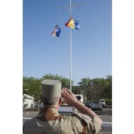 Le  general de division Patrick Bréthous, commandant la force Barkhane, salue les couleurs lors d'une cérémonie de lever des couleurs sur la base aérienne 172 Fort-Lamy à N'Djamena.