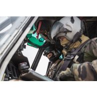 Un pilote et son co-pilote effectuent les vérifications nécessaires au niveau du tableau de bord de leur hélicoptère Caracal EC-725, avant décollage pour une mission depuis la base aérienne 172 Fort-Lamy à N'Djamena.