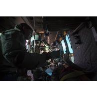 Prise en charge d'un soldat blessé à bord d'un hélicoptère de transport EC-725 Caracal par les aviateurs de l'escadron 1/67 Pyrénées, dans le cadre d'un exercice MEDEVAC (medical evacuation) ou EVASAN (évacuation sanitaire), au milieu de la brousse africaine.