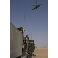 Un hélicoptère Puma SA-330 survole un LRU du 1er RA lors d'une traversée du désert en convoi, dans le cadre de l'opération Charente.