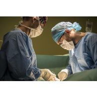 Deux chirurgiens du SSA (Service de santé des armées) pratiquent une opération viscérale sur un civil blessé par balle , au bloc opératoire du PSU (pôle de santé unique) de N'Djamena.