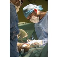 Deux chirurgiens du SSA (Service de santé des armées) pratiquent une opération viscérale sur un civil blessé par balle , au bloc opératoire du PSU (pôle de santé unique) de N'Djamena.