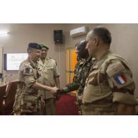 Le général d'armées Pierre de Villiers, chef d'état major des armées, salue les officiers de liaison présents à une réunion de commandement, en présence du général de division Ahmed Mohamed, adjoint au chef d'état major des armées nigeriennes, lors de sa visite à Niamey.