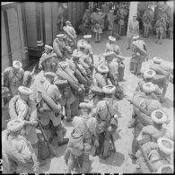 Des goumiers du 11e tabor, paquetage et fusil MAS 36 sur le dos, s'apprêtent à embarquer dans un train pour quitter l'Indochine.