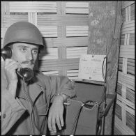 Le sergent Louis Lavie utilise la cabine téléphonique souterraine du camp retranché de Na San.