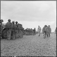 Au cours d'une visite du camp de Na San en cours d'évacuation, le général Cogny, commandant les FTVN (forces terrestres Nord-Vietnam), croise une colonne de parachutistes qui attend d'embarquer dans un avion.
