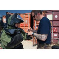 La journaliste de la DICOD, en tenue lourde de protection EOD-9, écoute les instructions d'un plongeur-démineur du GPD (groupement de plongeurs démineurs) de Toulon avant de réaliser un exercice pour la rubrique 