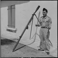 Un soldat présentant une fusée éclairante et sa rampe de lancement.