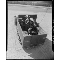 Plan en plongée d'apprentis en cours de radiocommunication, à bord d'un camion de transmissions.