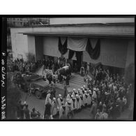 Des soldats portent le cercueil du général Philippe Leclerc à l'intérieur de la salle Pierre Bordès, à Alger, transformée en chapelle ardente, sous le regard d'autorités civiles, militaires et de la population civile.
