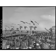 Des soldats transportent les cercueils du général Philippe Leclerc et de ses compagnons, à bord d'un croiseur, à quai, sur le port d'Alger.