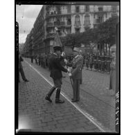 Le général Guy Schlesser remet un drapeau à un officier lors de la cérémonie de commémoration du 11 novembre à Alger.