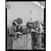 Deux élèves de l'Ecole de l'Air de Cap Matifou, s'exercent à travailler sur une pièce d'avion, dans un atelier.