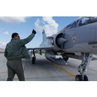 L'avion qatari Mirage 2000-5 QA 96 au roulage pour un départ en mission, suivant les instructions gestuelles du mécanicien de piste.