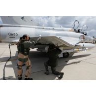 Avant le départ en mission, un pilote qatari effectue la visite de contrôle avant vol de son avion Mirage 2000-5 QA 85 avec son mécanicien de piste.