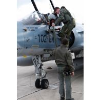 Au retour de mission, le pilote descend l'échelle de son avion Mirage 2000-5 102-EM 63 de l'EC (escadron de chasse) 1/2 Cigognes accueilli par son mécanicien de piste.