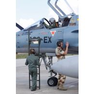 Pilote au cockpit de l'avion Mirage 2000-5 102-EX 40 de l'EC (escadron de chasse) 1/2 Cigognes en présence du sergent féminin mécanicien de piste vecteur de l'ESTA (escadron de soutien technique aéronautique) 2E Chalosse de la BA 118 et d'un sergent armurier (