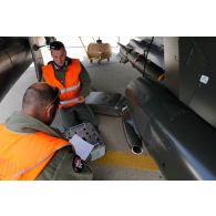Deux mécaniciens de piste effectuent la maintenance d'un avion Mirage 2000D.