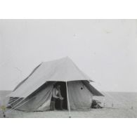 [Un militaire sous une tente dans un désert].