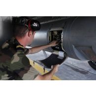 Au retour de mission, un technicien récupère l'enregistrement d'images dans le Pod Reco NG (système de reconnaissance de nouvelle génération) du Rafale sur la base aérienne de Sigonella pour son exploitation.