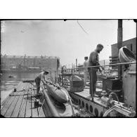 Cherbourg. Bassin Napoléon. A bord d'un sous-marin à quai. Le nettoyage du pont et la cuisine. [légende d'origine]