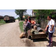 Les habitants de Priluzje,équipés de jerricans, assistent à l'arrivée du camion citerne.