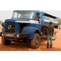 Point de contrôle à l'entrée d'une emprise : contrôle d'identité du chauffeur d'un camion-citerne Renault de livraison d'eau local par un militaire malien.