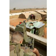 Poste d'observation surplombant le camp du 3e RIMa sur le toit d'un bâtiment aux abords de l'aéroport de Bamako. Une sentinelle observe les alentours à l'aide du dispositif de visée et de localisation d'un poste de tir Eryx sur trépied.