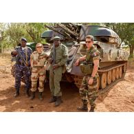 Deux militaires maliens dont un adjudant et deux capitaines français du 3e RIMa devant un canon antiaérien automoteur chenillé ZPU-23-4 à quadruple canon de 23 mm de l'AMA (armée malienne).
