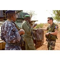 Deux militaires maliens dont un adjudant discutent avec un capitaine français du 3e RIMa devant un canon antiaérien automoteur chenillé ZPU-23-4 à quadruple canon de 23 mm de l'AMA (armée malienne).