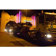 Passage d'une porte d'entrée de ville lors de l'arrivée de nuit à Bamako du convoi du GTIA 2 par un camion Mercedes Actros EPB (engin porte-blindés) transportant un AMX-10 RC.