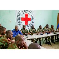 Dans une salle de formation, ornée du drapeau du CICR (comité international de la Croix-Rouge), des stagiaires du Bénin et du Sénégal, disposant d'un manuel d'instruction (édité par l'état-major des Armées de la république du Mali et CICR), écoutent le cours.