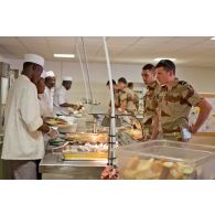 Cuisiniers au service et militaires clients de la chaîne de restauration du restaurant France de l'Economat des armées à N'Djamena au Tchad.