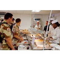 Cuisiniers au service et militaires clients de la chaîne de restauration du restaurant France de l'Economat des armées à N'Djamena au Tchad, en présence du chef d'exploitation.