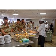 Cuisiniers au service et militaires clients (dont un armurier ou petaf) de la chaîne de restauration du restaurant France de l'Economat des armées à N'Djamena au Tchad.