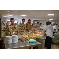 Cuisiniers au service et militaires clients (dont un armurier ou petaf) de la chaîne de restauration du restaurant France de l'Economat des armées à N'Djamena au Tchad.