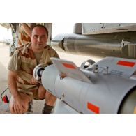Portrait d'un adjudant-chef de l'armée de l'Air, chef des armuriers sur avions de combat Mirage-2000D, au montage d'une bombe SAMP (sol-air moyenne portée) sous aile.