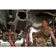 Portrait d'un adjudant de l'armée de l'Air, armurier sur avions de combat Mirage-2000D, au montage d'une bombe SAMP (sol-air moyenne portée) sous aile.