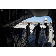 Des mécaniciens navigants encadrent le déchargement de fret depuis la soute d'un avion A400 M sur l'aéroport de Juliana à Saint-Martin, aux Antilles.