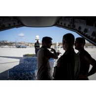 Des mécaniciens navigants encadrent le déchargement de fret depuis la soute d'un avion A400 M sur l'aéroport de Juliana à Saint-Martin, aux Antilles.