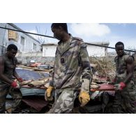 Des stagiaires du Service militaire adapté (SMA) déblayent les déchets qui encombrent une rue du quartier de Sandy Ground à Marigot sur l'île de Saint-Martin, aux Antilles.