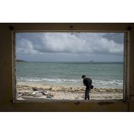 Le camérman Florent filme l'arrivée de la frégate de surveillance Ventôse parmi les ruines de bungalows sur la plage de Sandy Ground à Marigot sur l'île de Saint-Martin, aux Antilles.