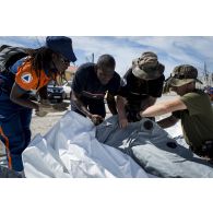 Des gendarmes installent une tente en coordination avec le personnel de la protection civile et des sapeurs-pompiers à Marigot sur l'île de Saint-Martin, aux Antilles.