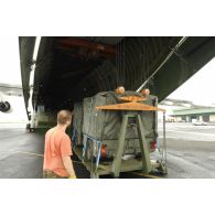 Chargement d'une remorque de cuisines de campagne dans l'avion cargo Antonov 124-100 par les membres d'équipage de l'avion.