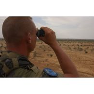 Un personnel de la patrouille observe au loin afin d'assurer la sécurité des éléments opérationnels de dépannage (EOD) au travail sur zone.