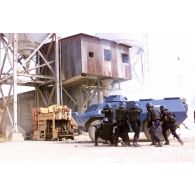 Les gendarmes mobiles équipés de tenues anti-émeute et de fusils à pompe se positionnent derrière un VBRG (véhicule blindé à roues de la gendarmerie) pour investir les bâtiments de l'usine.