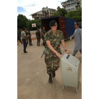 Déchargement d'un appareil électrique du container par un militaire luxembourgeois.