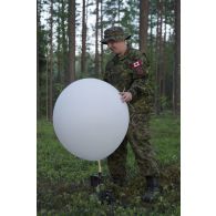 Un artilleur canadien gonfle un ballon sonde pour un relevé météorologique au camp de Pabradé, en Lituanie.