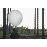 Un artilleur canadien effectue un relevé météorologique au moyen d'un ballon sonde au camp de Pabradé, en Lituanie.