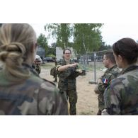 Un superviseur allemand mène un debriefing auprès des éléments d'une équipe médicale française au terme d'un exercice sanitaire au sein du camp de Pabradé, en Lituanie.